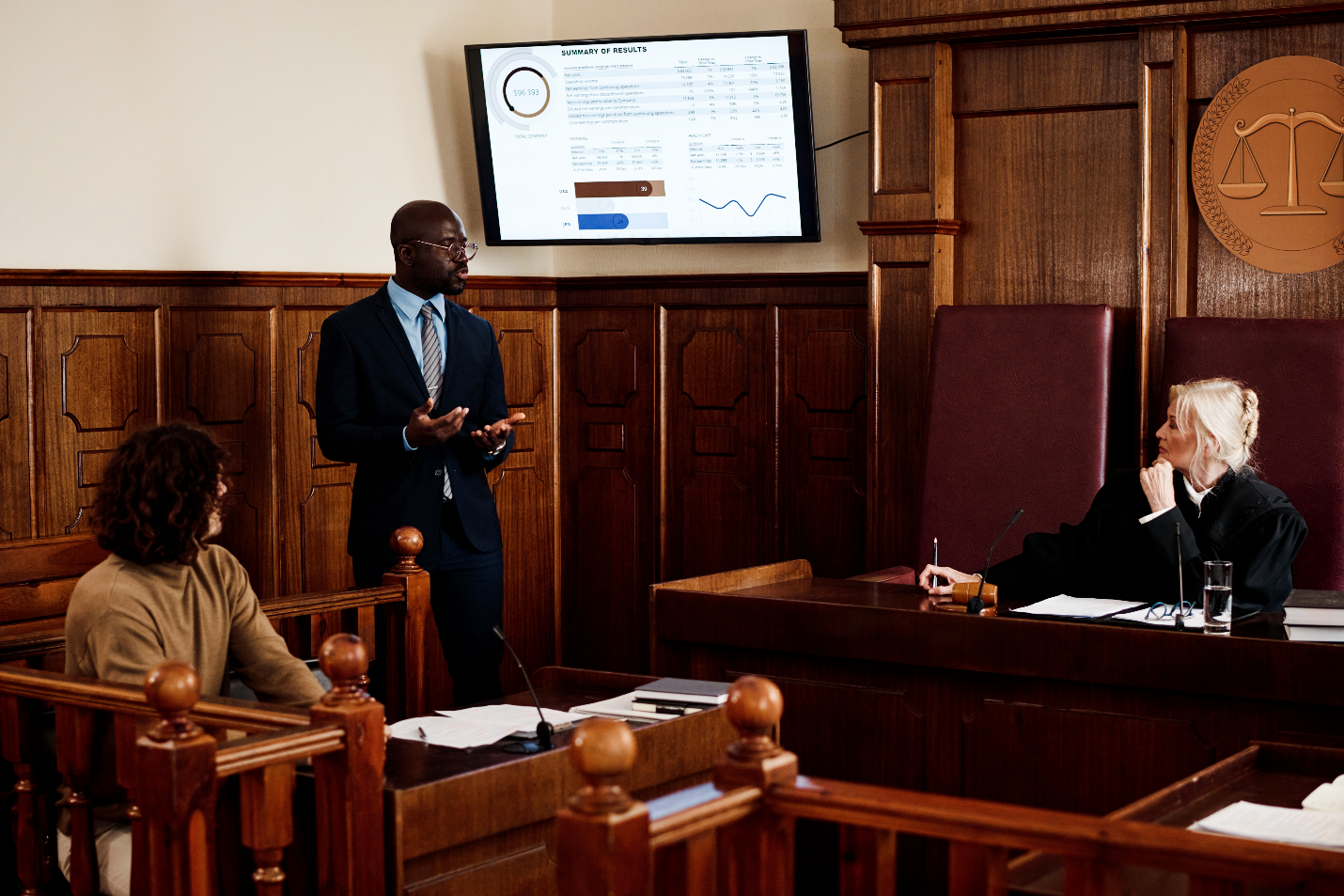 Attorney presents data on screen in courtroom with judge