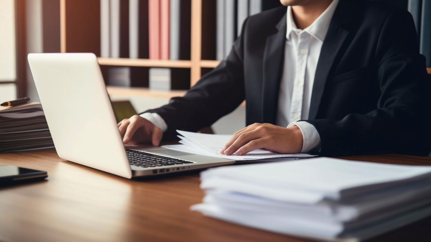 Attorney reviewing legal files beside a laptop